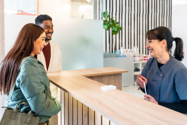 Patients speaking with a receptionist at a medical practice