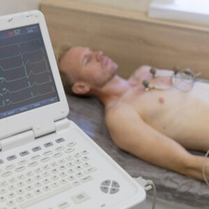 Patient undergoing an electrocardiogram with electrodes attached to his chest